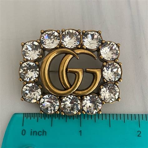 gucci bronze brooch.